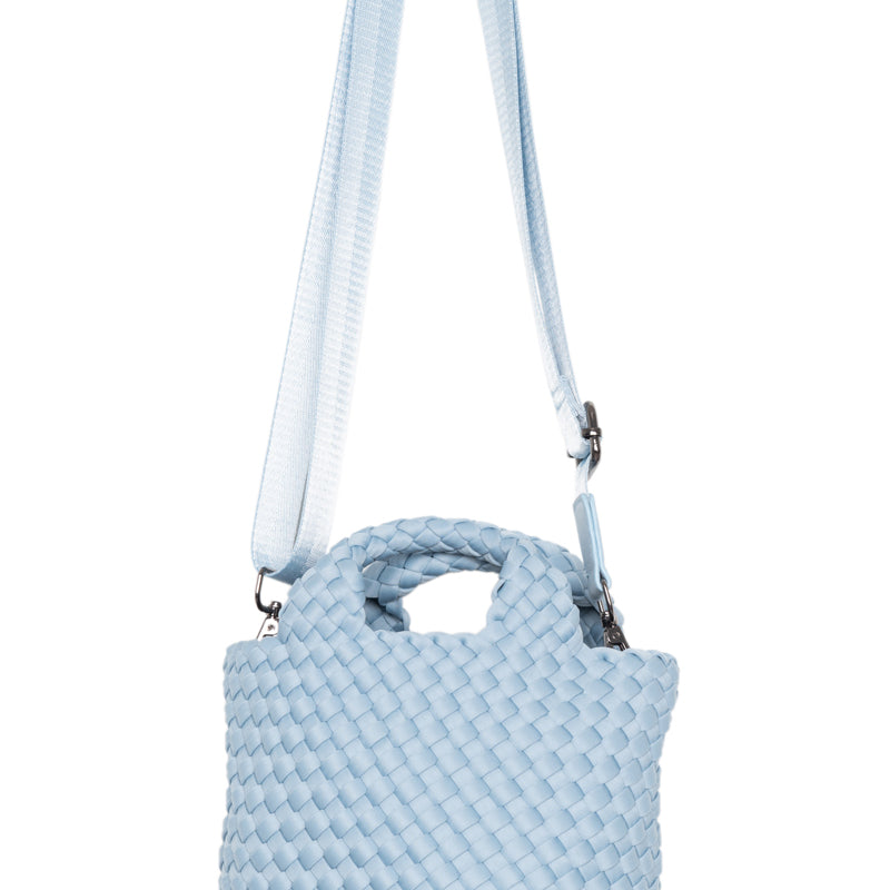 Light blue textured handbag with a strap on a white background