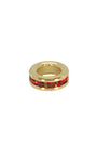 Gold charm with red gemstones on a white background