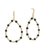 A pair of gold-tone teardrop dangle earrings with faceted black beads spaced along the open oval frame, shown on a plain white background.