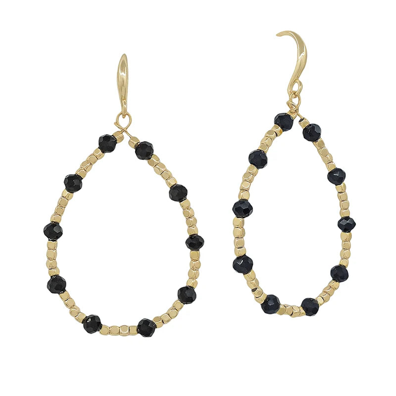 A pair of gold-tone teardrop dangle earrings with faceted black beads spaced along the open oval frame, shown on a plain white background.