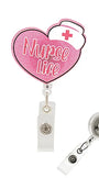 Pink heart-shaped retractable badge reel with 'Nurse Life' text and a white nurse hat graphic, shown with the clear plastic clip and reel attachment on a white background.