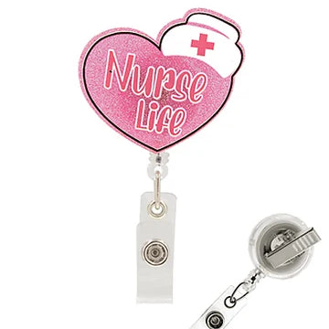 Pink heart-shaped retractable badge reel with 'Nurse Life' text and a white nurse hat graphic, shown with the clear plastic clip and reel attachment on a white background.