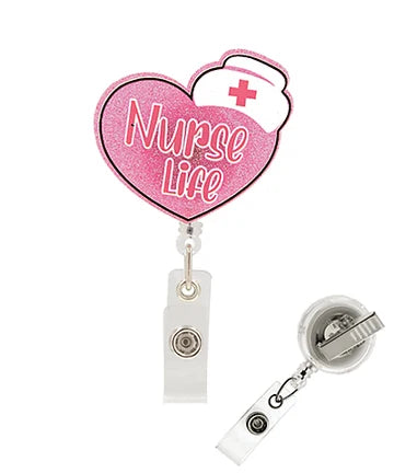 Pink heart-shaped retractable badge reel with 'Nurse Life' text and a white nurse hat graphic, shown with the clear plastic clip and reel attachment on a white background.