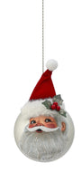 A round Christmas ornament featuring a printed Santa Claus face with a red hat, white beard, and holly accents, hanging from a silver chain against a white background.