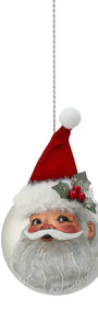 A round Christmas ornament featuring a printed Santa Claus face with a red hat, white beard, and holly accents, hanging from a silver chain against a white background.