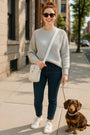 Woman walking a dog on a city sidewalk