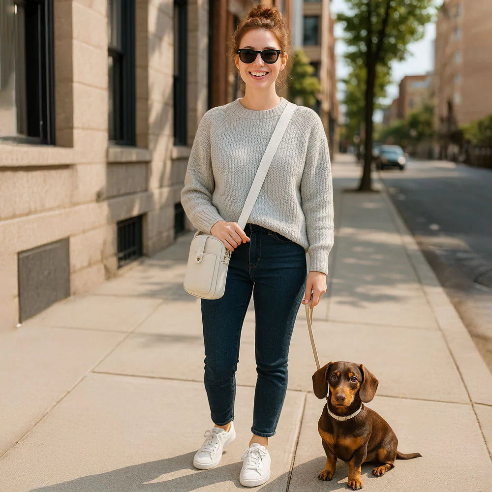 Woman walking a dog on a city sidewalk