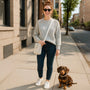 Woman walking a dog on a city sidewalk