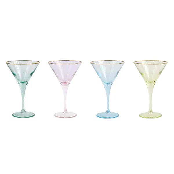 Four martini glasses with gold rims in different pastel colors on a white background