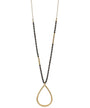 A long gold-tone necklace featuring a beaded strand with alternating sections of small black beads and gold spacer beads, culminating in a large open teardrop pendant.