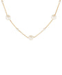 A delicate gold chain necklace featuring several round, off-white faux pearl beads spaced along the chain, shown against a plain white background.