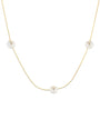 A delicate gold chain necklace featuring three small, round white pearl-like beads spaced evenly along the chain, displayed against a solid white background.
