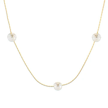 A delicate gold chain necklace featuring three small, round white pearl-like beads spaced evenly along the chain, displayed against a solid white background.