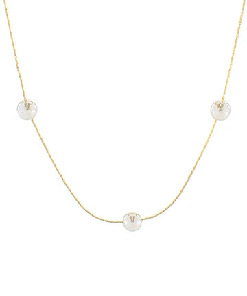 A delicate gold chain necklace featuring three small, round white pearl-like beads spaced evenly along the chain, displayed against a solid white background.