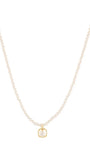 A delicate pearl necklace with a small gold pendant on a solid white background.