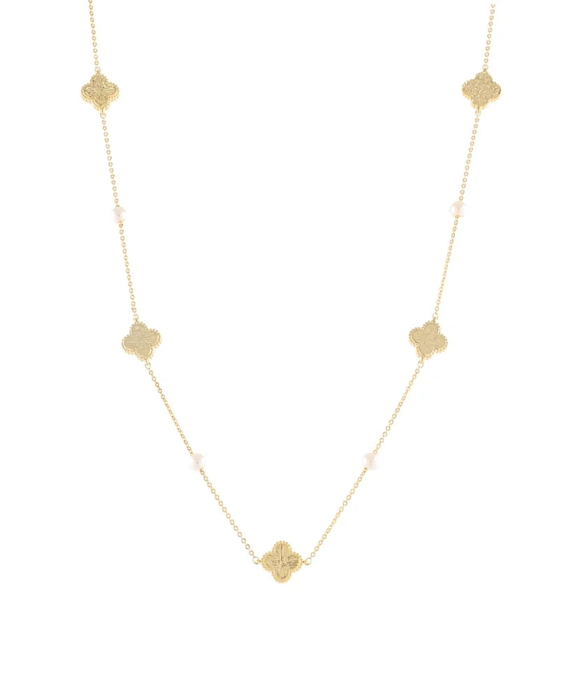 A delicate gold chain necklace featuring five textured gold quatrefoil (clover) charms spaced evenly along the chain, with small pale pink beads interspersed, set against a solid white background.