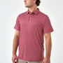 A man wearing a short-sleeve polo shirt with a red and white geometric checkered pattern, shown from the side against a plain white studio background.