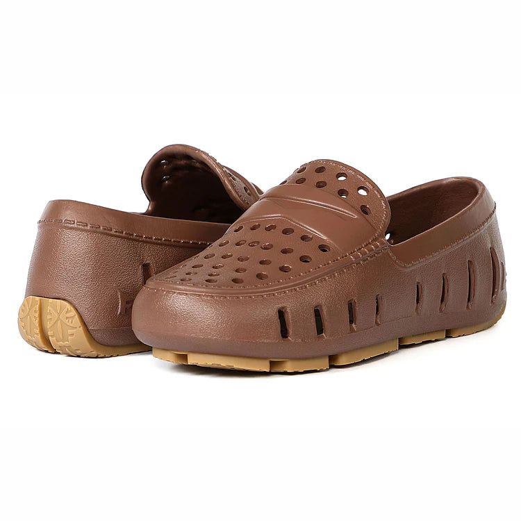 Pair of brown clogs with perforated design on a white background