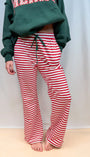 Red and white striped track pants with green drawstring waist and straight legs