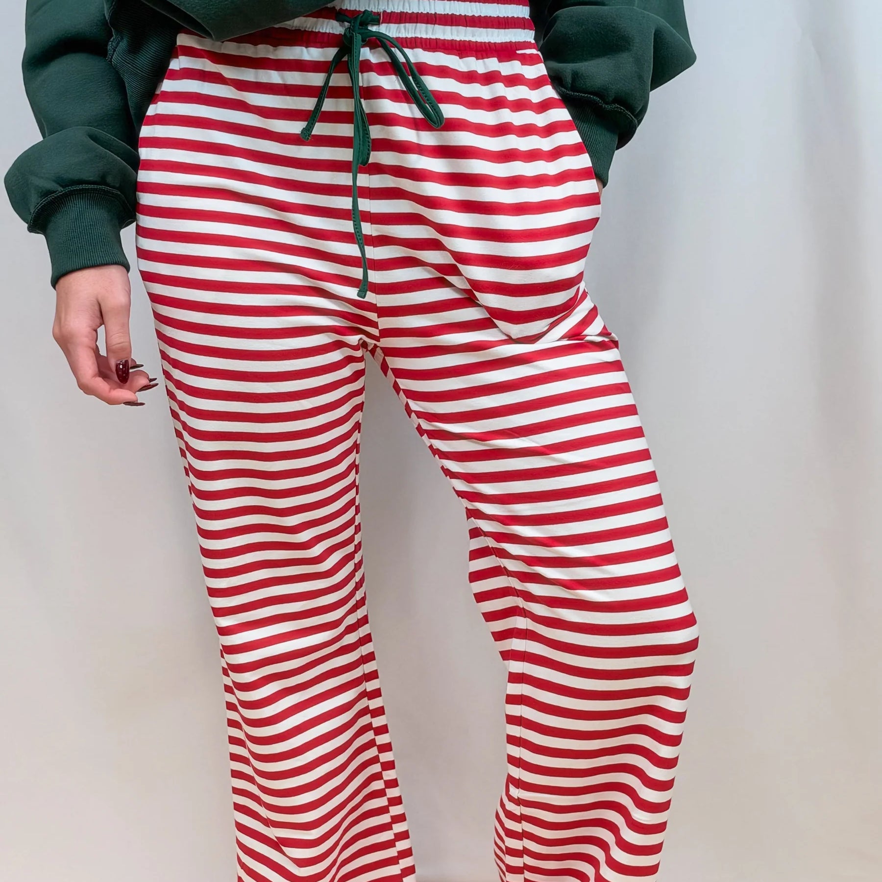 Red and white striped track pants with green drawstring waist and straight legs