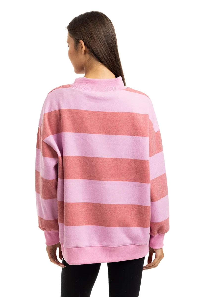 Person wearing a pink and red striped sweater on a white background