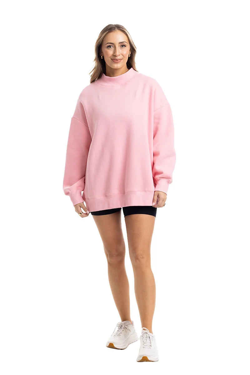 Woman wearing a pink oversized sweatshirt on a white background