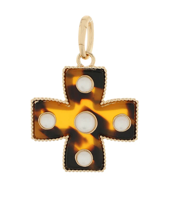 Tortoiseshell cross pendant with gold accents on a white background