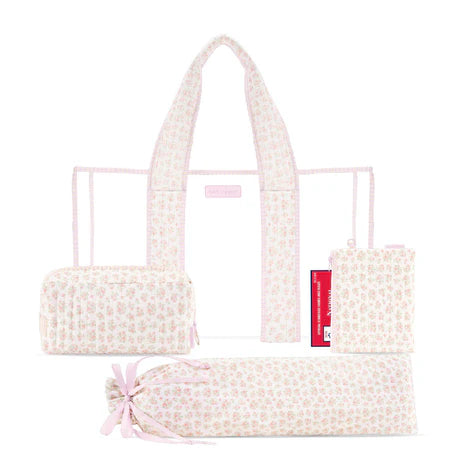 A light pink and white floral patterned diaper bag set shown on a white background, including the main tote bag, a smaller zip pouch, a rolled storage bag tied with a pink ribbon, and a folded view of the bag.