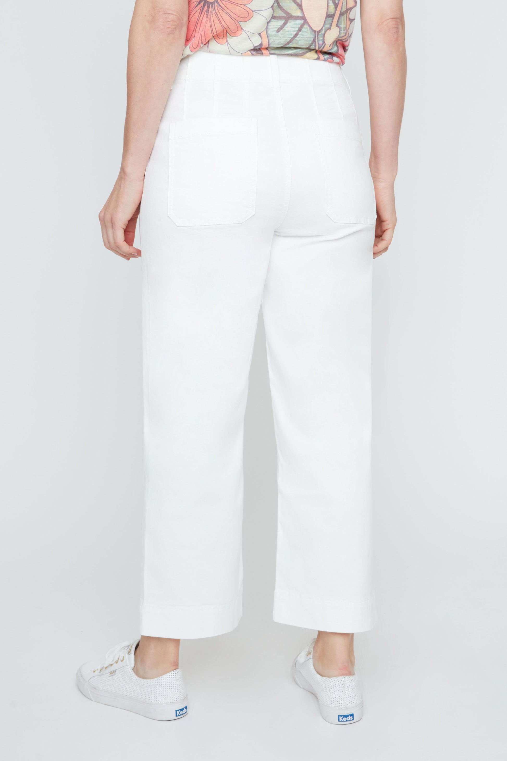 Person wearing white pants on a plain background