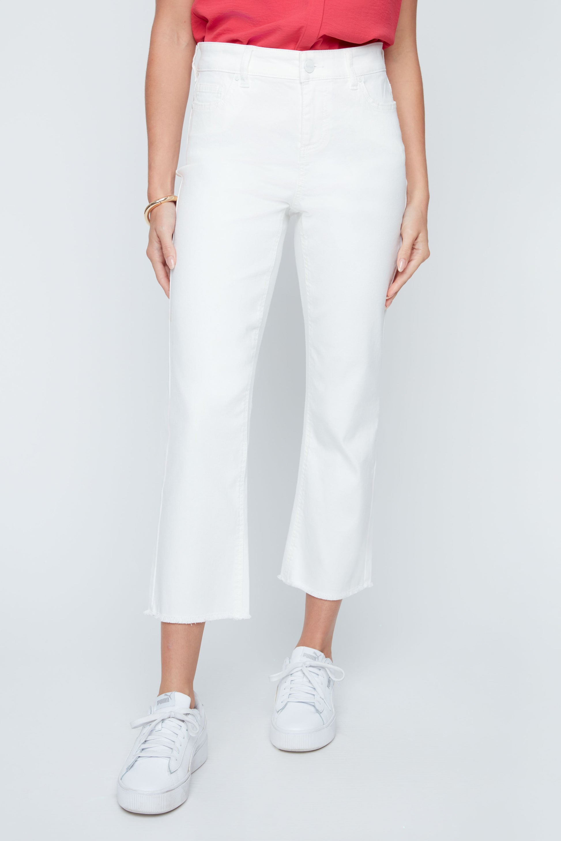 Person wearing white pants and white sneakers on a light gray background