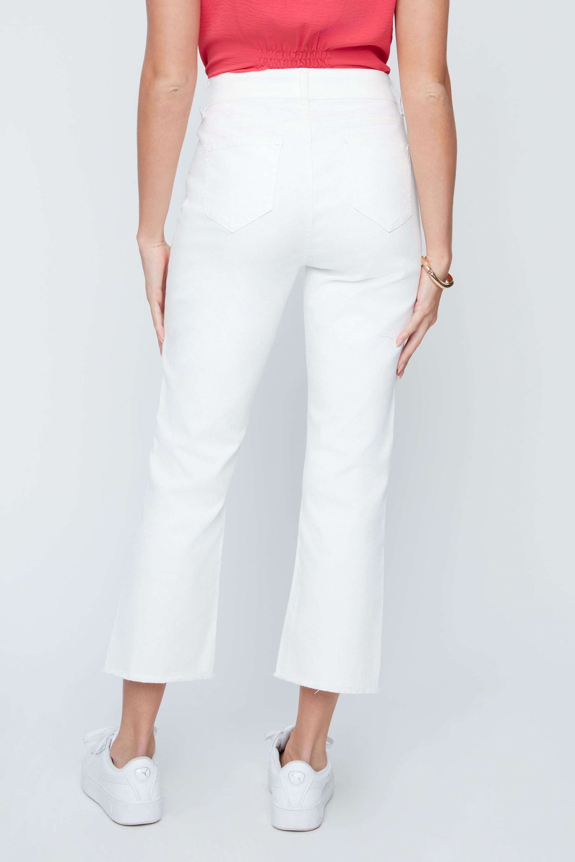 Person wearing white pants on a plain background
