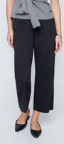 Person wearing black pants and a checkered top on a white background