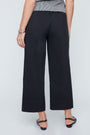 Person wearing black wide-leg pants on a white background