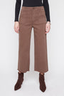 A model wearing brown wide-leg cropped pants with a black long-sleeve top and dark brown pointed-toe ankle boots, shown from the waist down against a light gray studio background.