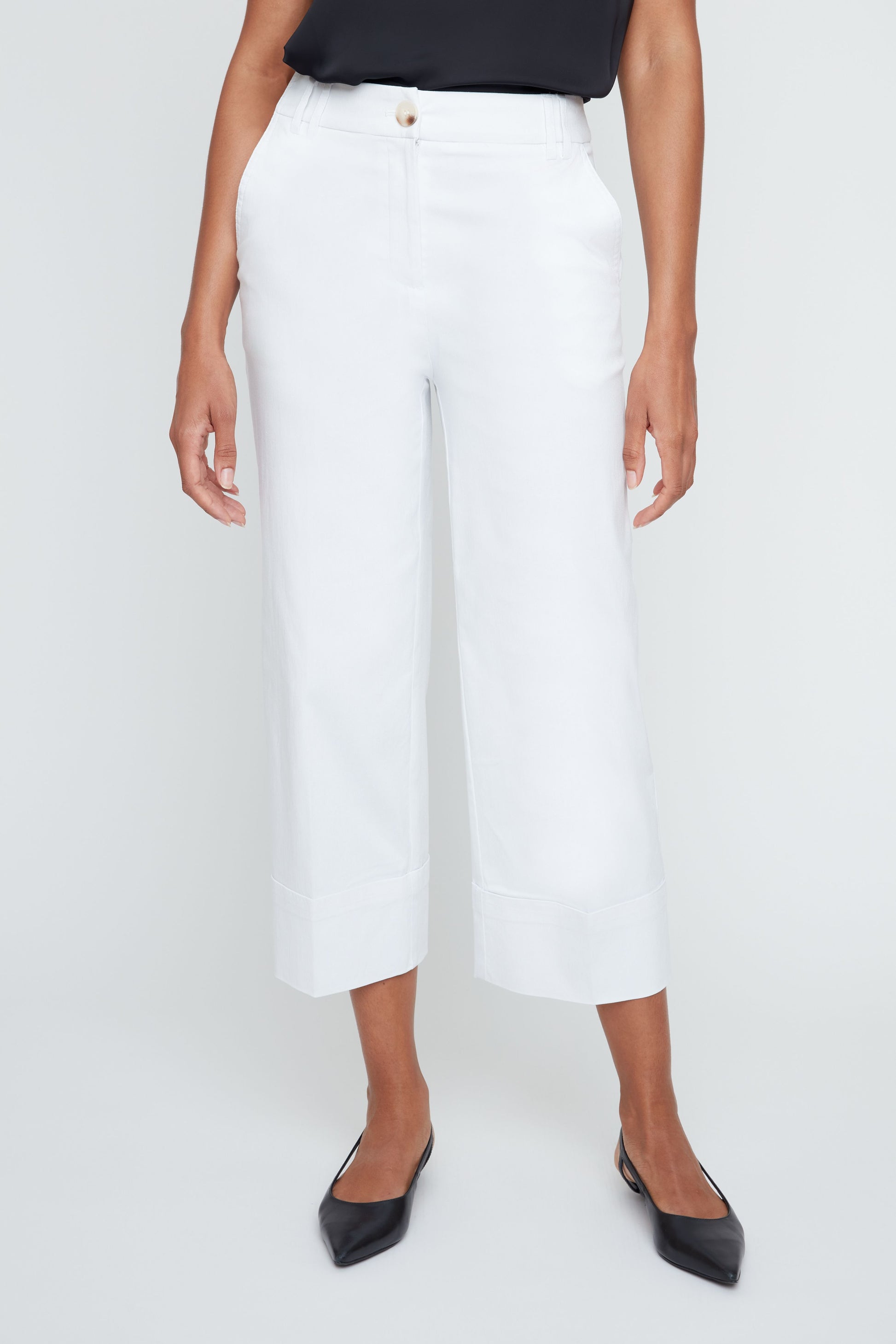 Person wearing white pants on a plain background