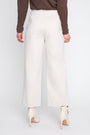 Person wearing white wide-leg pants with a plain background