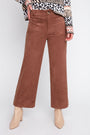 Brown corduroy pants worn by a person on a white background