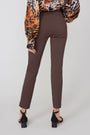 Brown pants worn by a person with a leopard print top on a white background