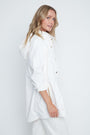 Woman wearing a white shirt with a plain background