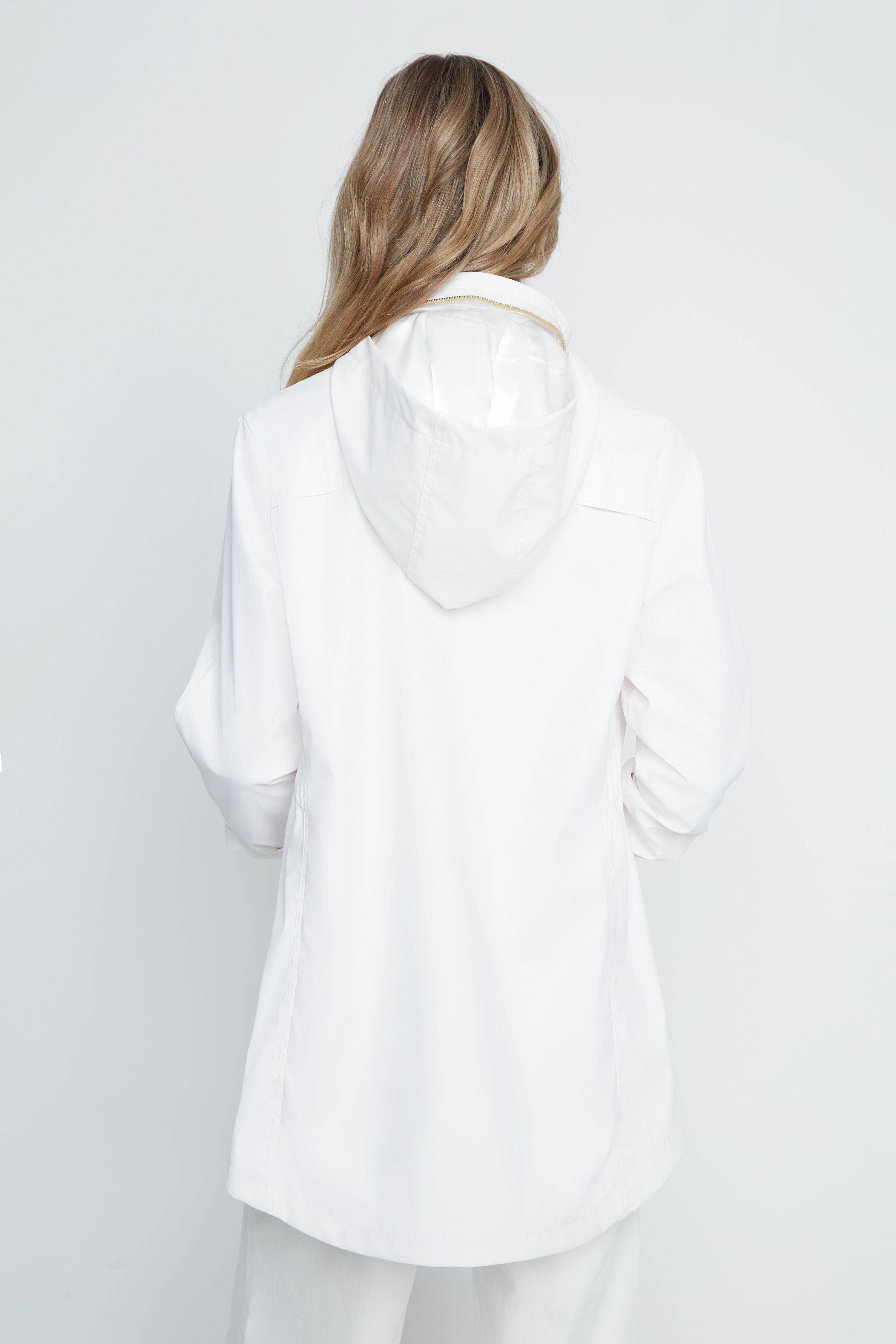 Person wearing a white oversized shirt against a plain background
