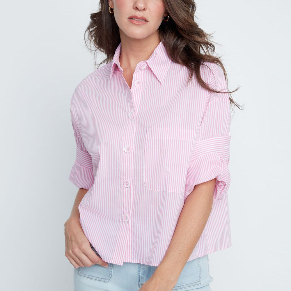 Woman wearing a pink striped shirt and light blue jeans against a white background