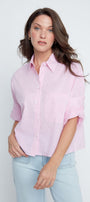 Woman wearing a pink striped shirt and light blue jeans against a white background