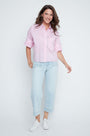 Woman wearing a light pink shirt and light blue jeans on a white background