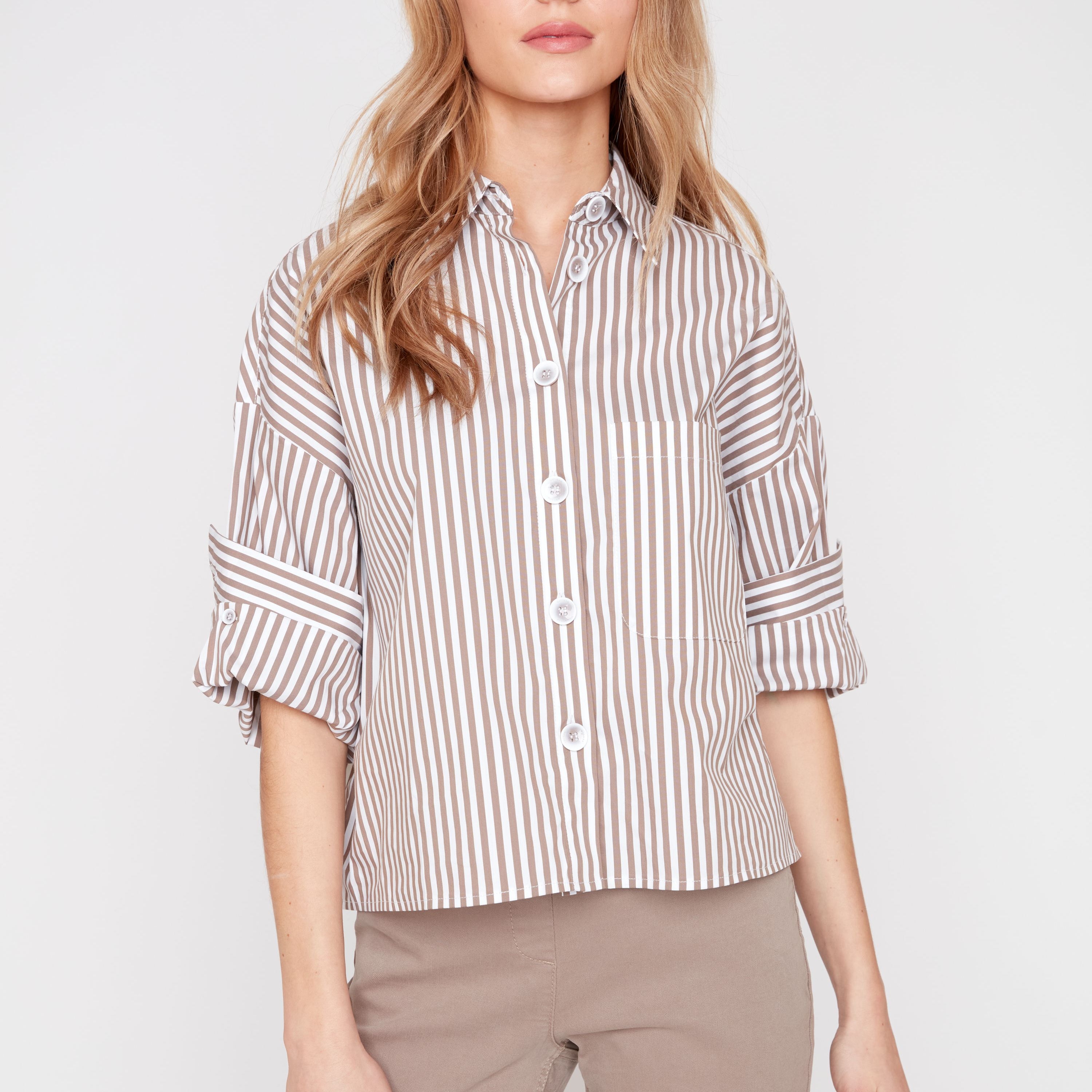Woman wearing a striped shirt and beige pants on a white background