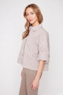 Woman wearing a striped shirt and beige pants on a white background