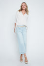 Woman wearing a white blouse and light blue pants on a white background