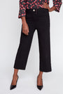 Person wearing black cropped pants with a floral blouse on a white background