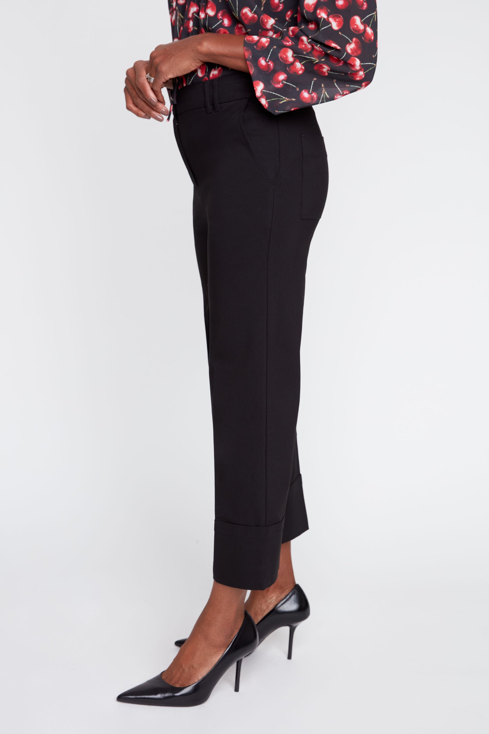 Person wearing black pants and black high heels on a white background