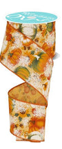 A spool of decorative ribbon with an autumn pumpkin and leaf pattern, featuring orange, green, and white motifs on a cream background with a glittery finish. The spool has a light blue label at the top.