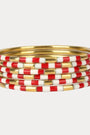 Stack of red, white, and gold bangles on a light gray background
